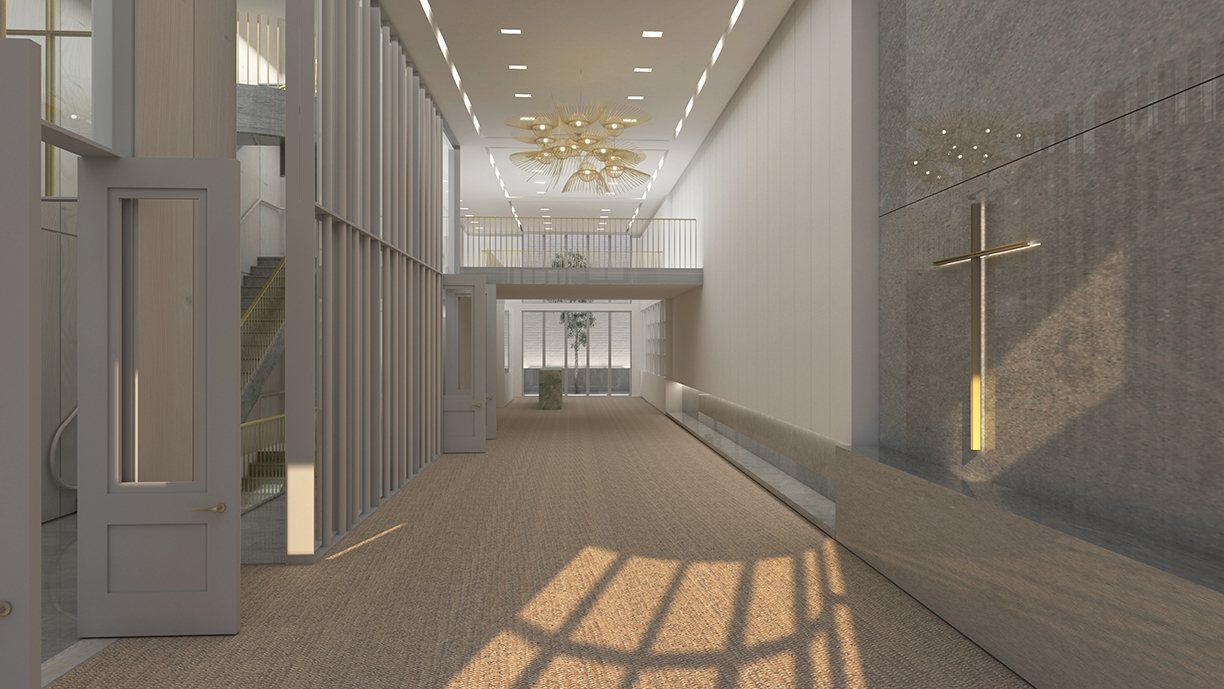 A long hall with a brass cross on a stone wall and warm light falling across the floor.
