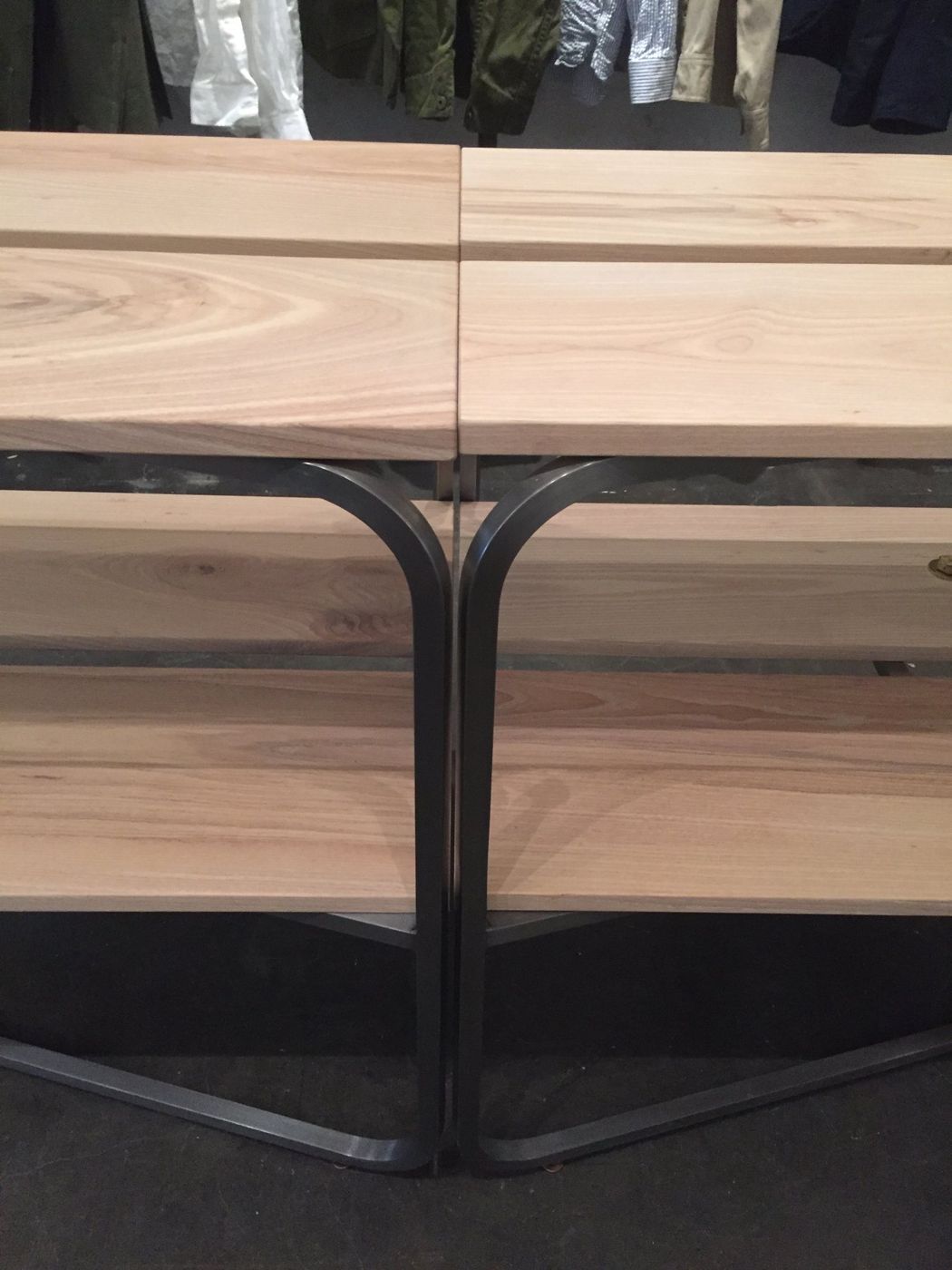 Two tables butted end to end, their bent steel legs meeting under the planks.
