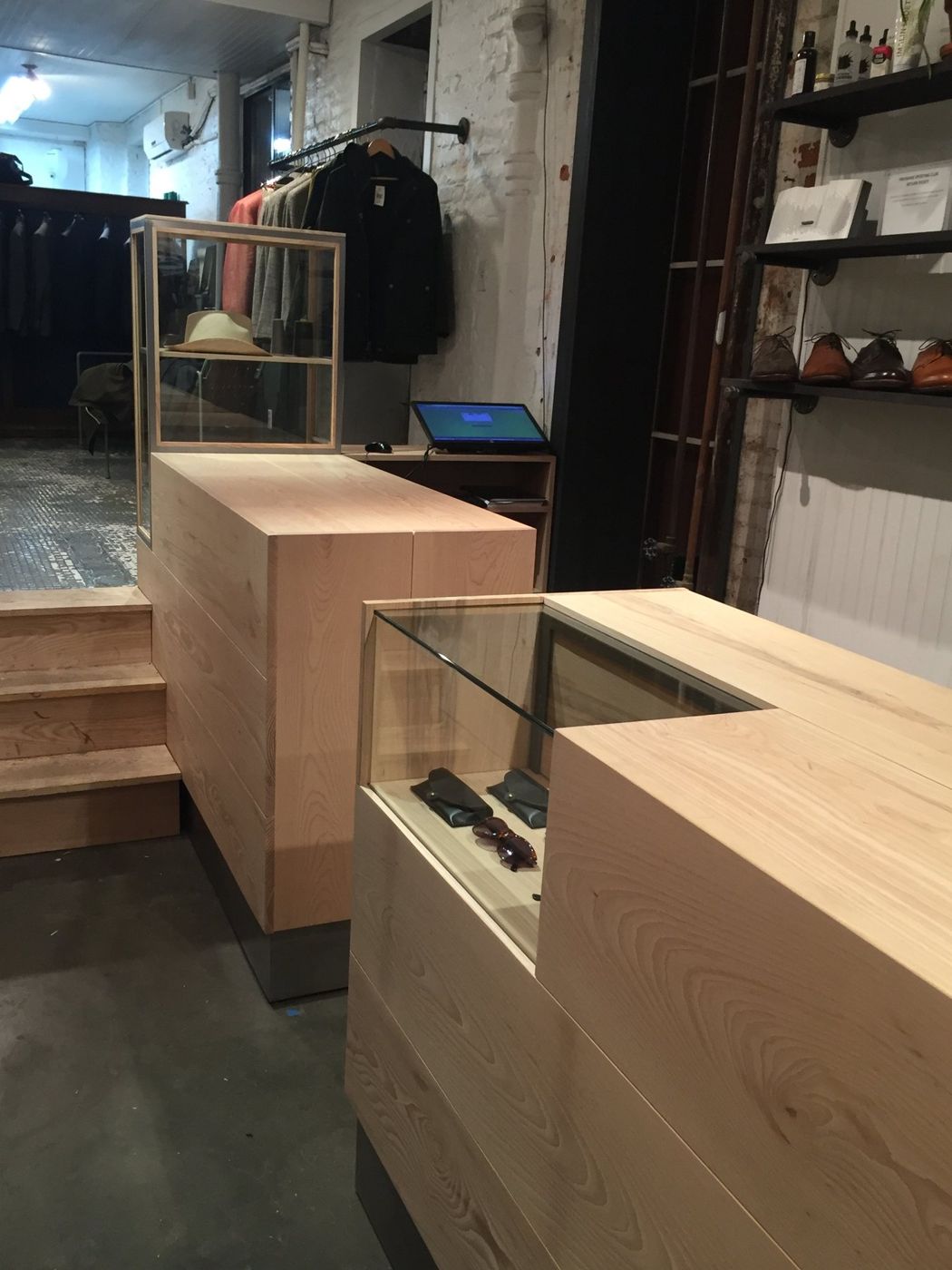 A pale timber counter with glass display cases on a concrete floor.