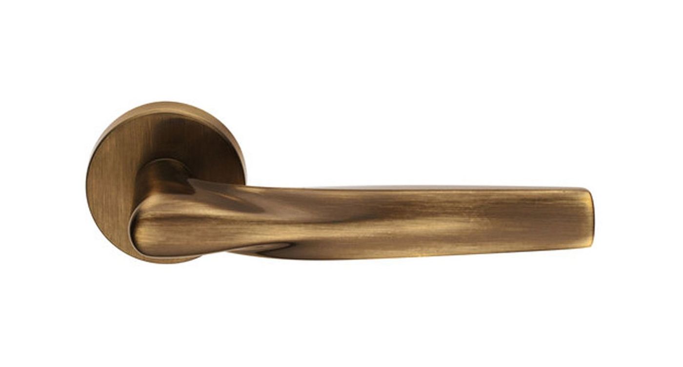 A bronze-toned door lever on a round rose, seen from the side on white.