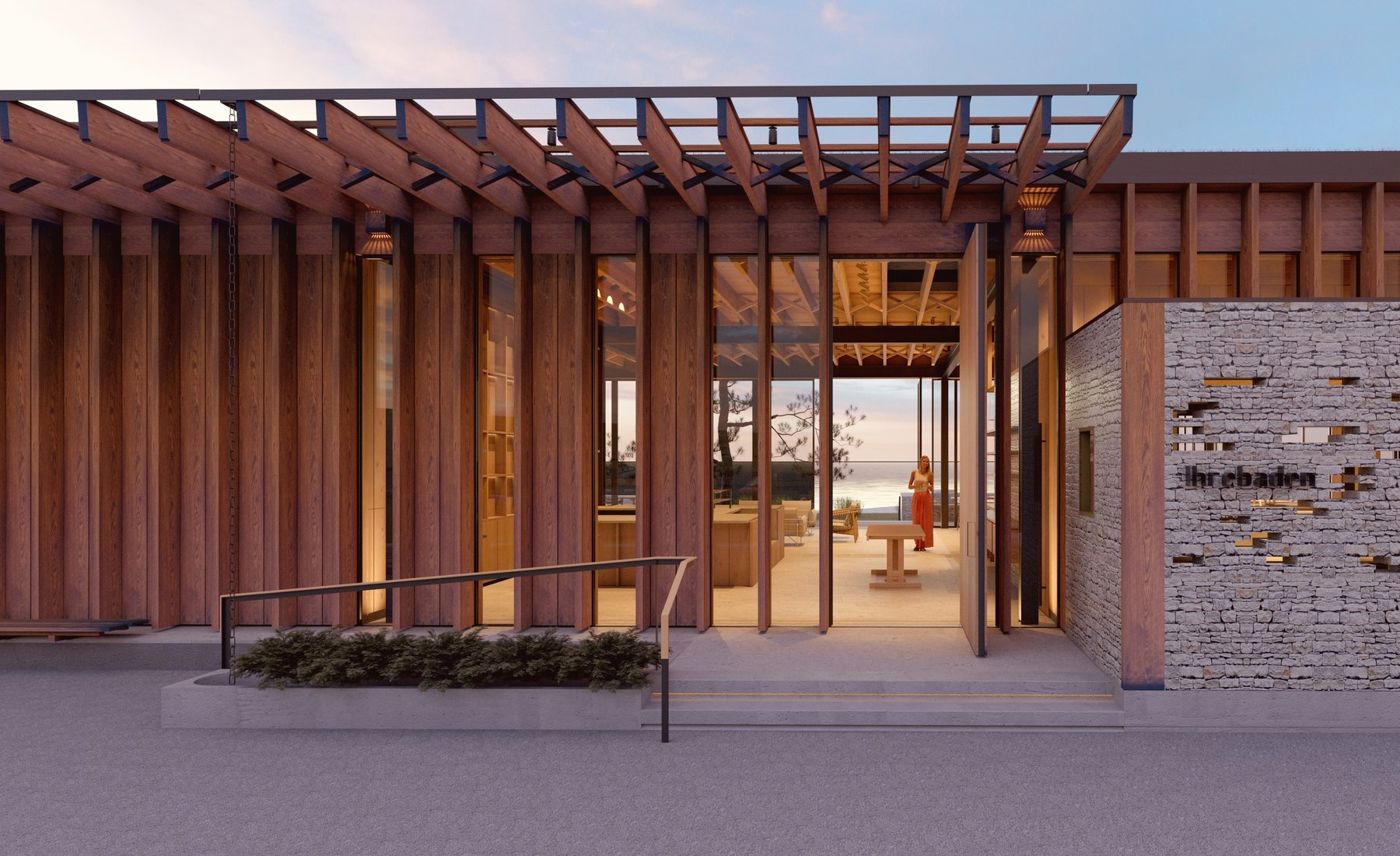 The timber colonnade and limestone wall at dusk, the entrance lit from within.