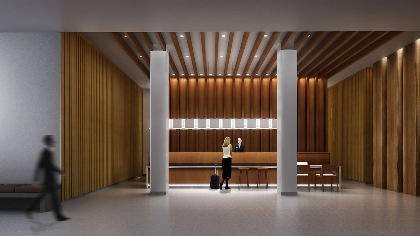 A reception desk under a ribbed timber ceiling, framed by two white columns.
