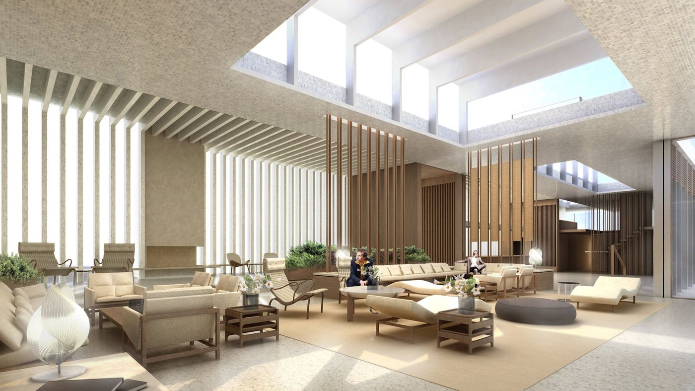 A tall public room with timber screens, clerestory light and groups of low pale seating.