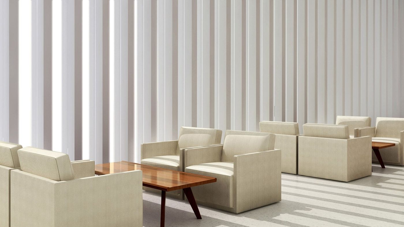 Pale armchairs and a timber table set against tall white vertical fins.