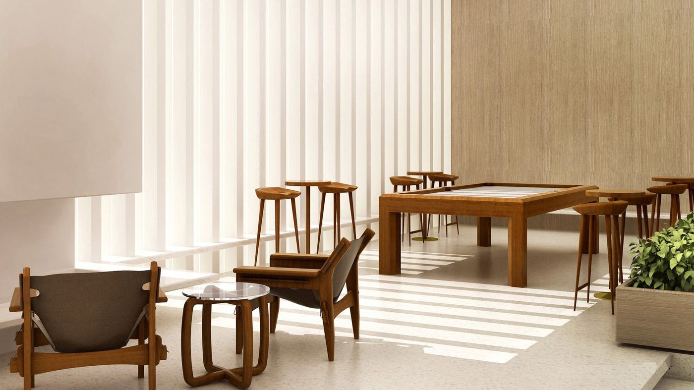 A timber games table, bar stools and lounge chairs in a pale room with vertical fins.
