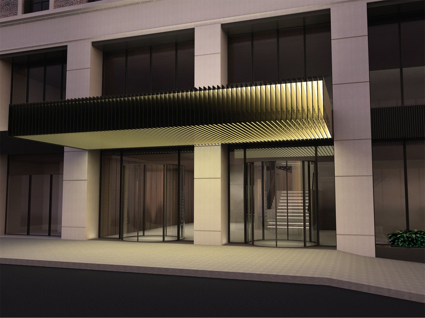 A lit canopy of fine slats over revolving doors set between pale stone piers.
