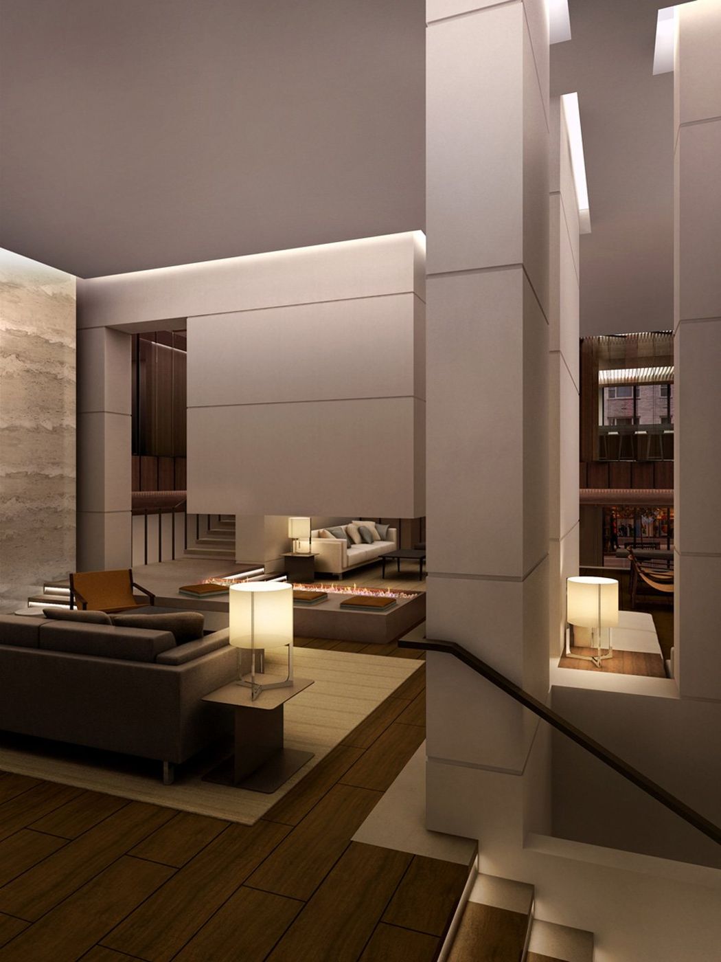 A tall stone-walled room with a sofa, lamp and a stair opening at the edge.