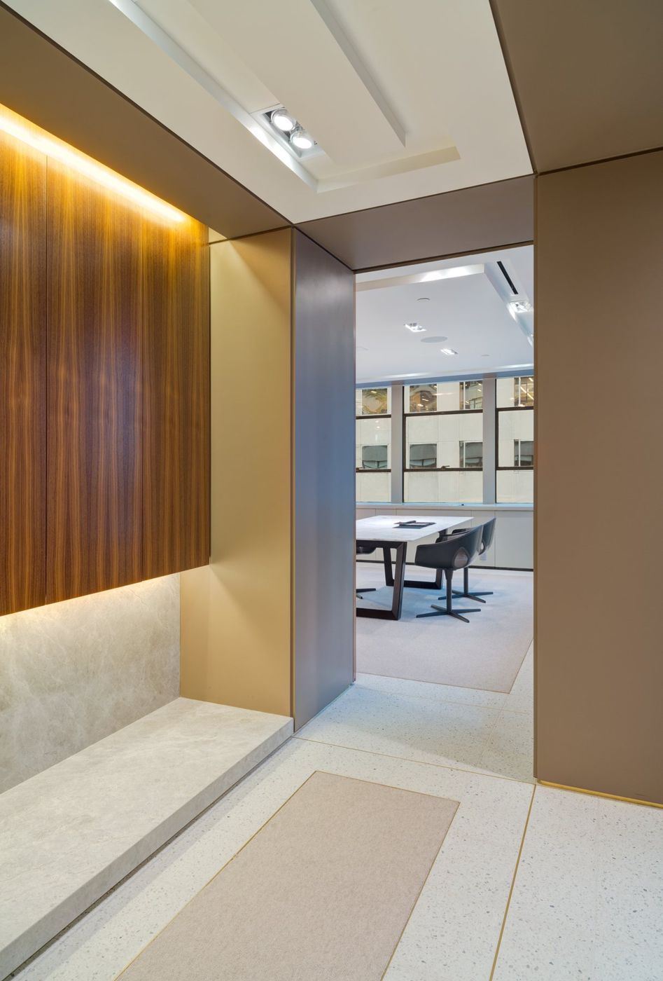 A lit walnut alcove with a stone ledge, a passage leading on to a table by the window.